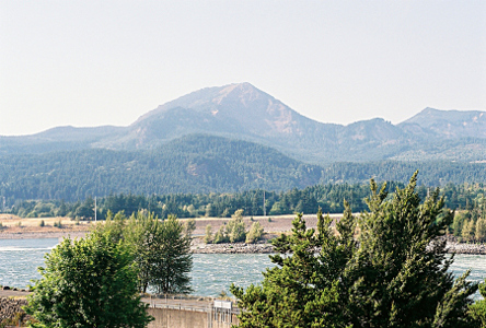 [Looking across the top of the dam to an evergreen covered mountain on the opposite shore of the river.]